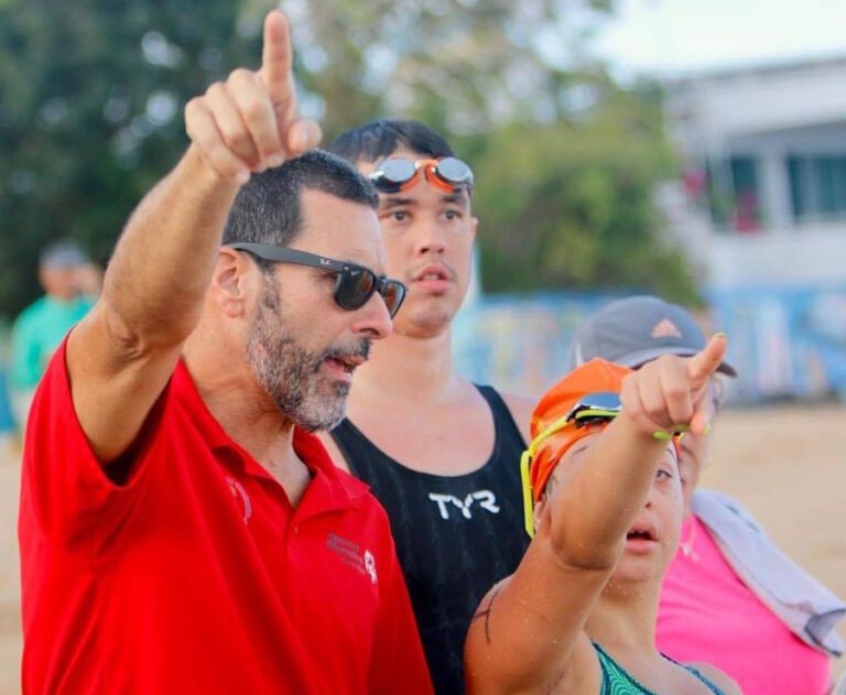 Arnaldo impartiendo instrucciones a los atletas Summer Mora y Esteban Rodríguez, en un clasificatorio nacional de aguas abiertas de Special Olympics Puerto Rico.